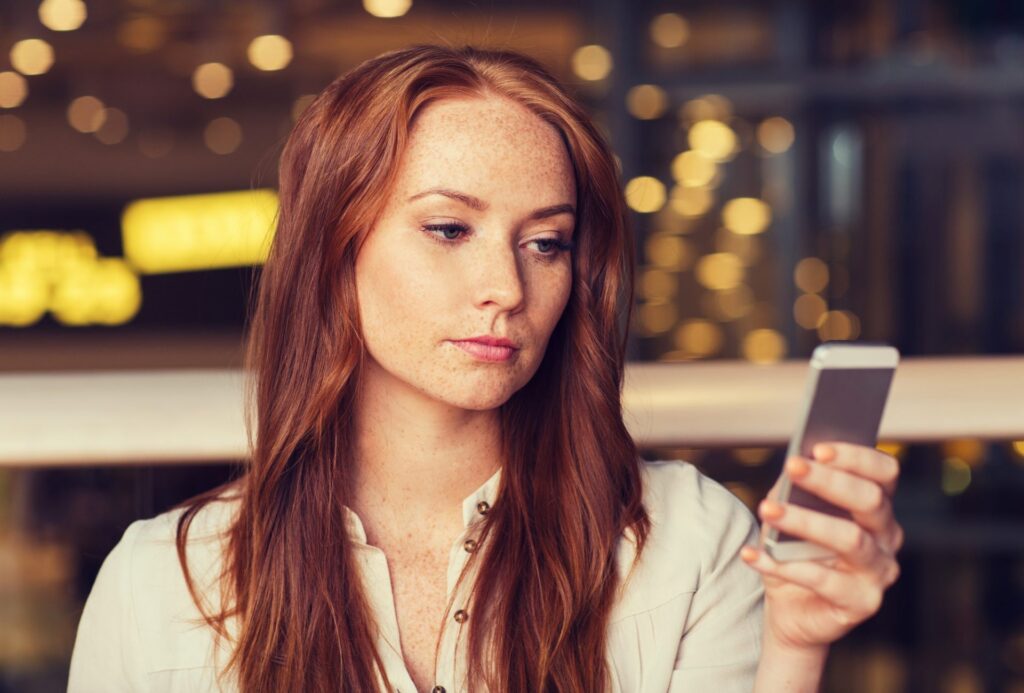 woman with smartphone and coffee at restaurant