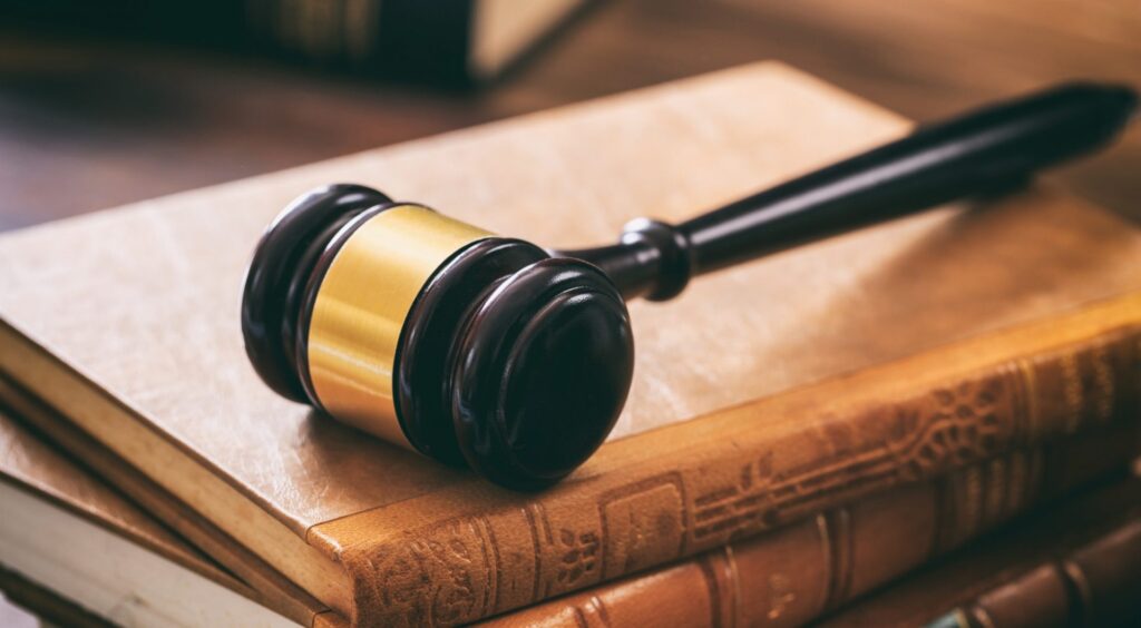 Judge gavel on law books, wooden desk