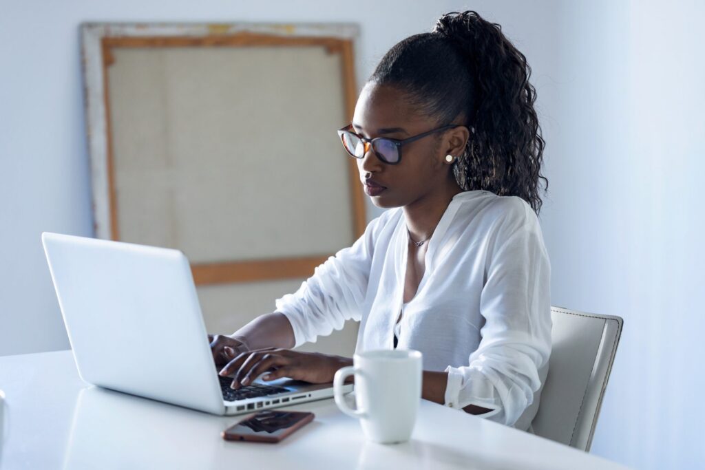 Onderwijs op afstand - Live trainingen zonder het huis te verlaten 11 Pretty young business woman working with laptop in the office.