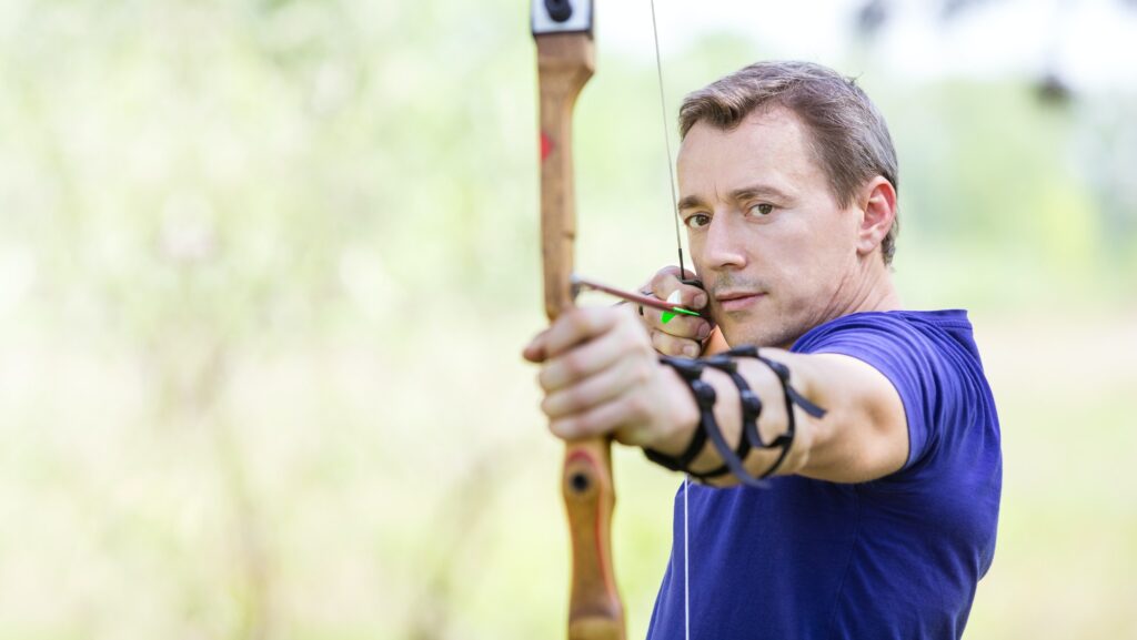 Bowman aiming arrow at target