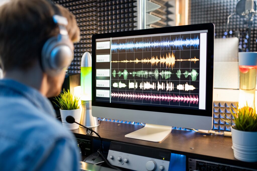Waveform sound visualization on computer screen with audio editor in front
