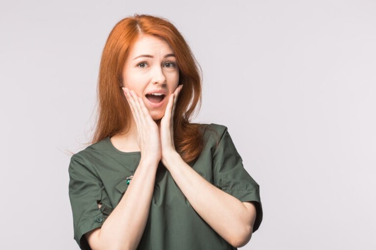 Surprised redhead young woman on white background