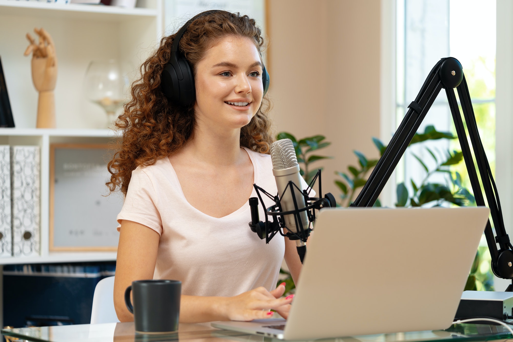 Coaching Online Leeromgeving 5 Woman vlogger looking at laptop and recording video with microphone