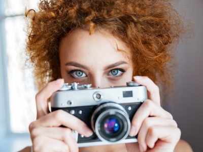 attractive-redhead-woman-photographer-using-old-camera