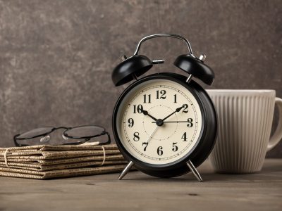 newspapers-glasses-alarm-clock-and-coffee-cup-on-desktop