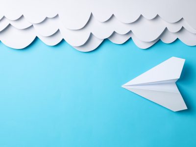 Paper clouds and plane on blue background. Travel