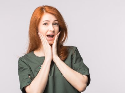 Surprised redhead young woman on white background